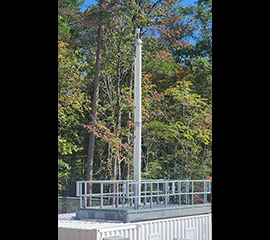 In front of trees, the aerosol stack sticks up from the top of the Aerosol Observing System container at ARM's Bankhead National Forest atmospheric observatory. Photo is by Mark Spychala, Argonne National Laboratory.