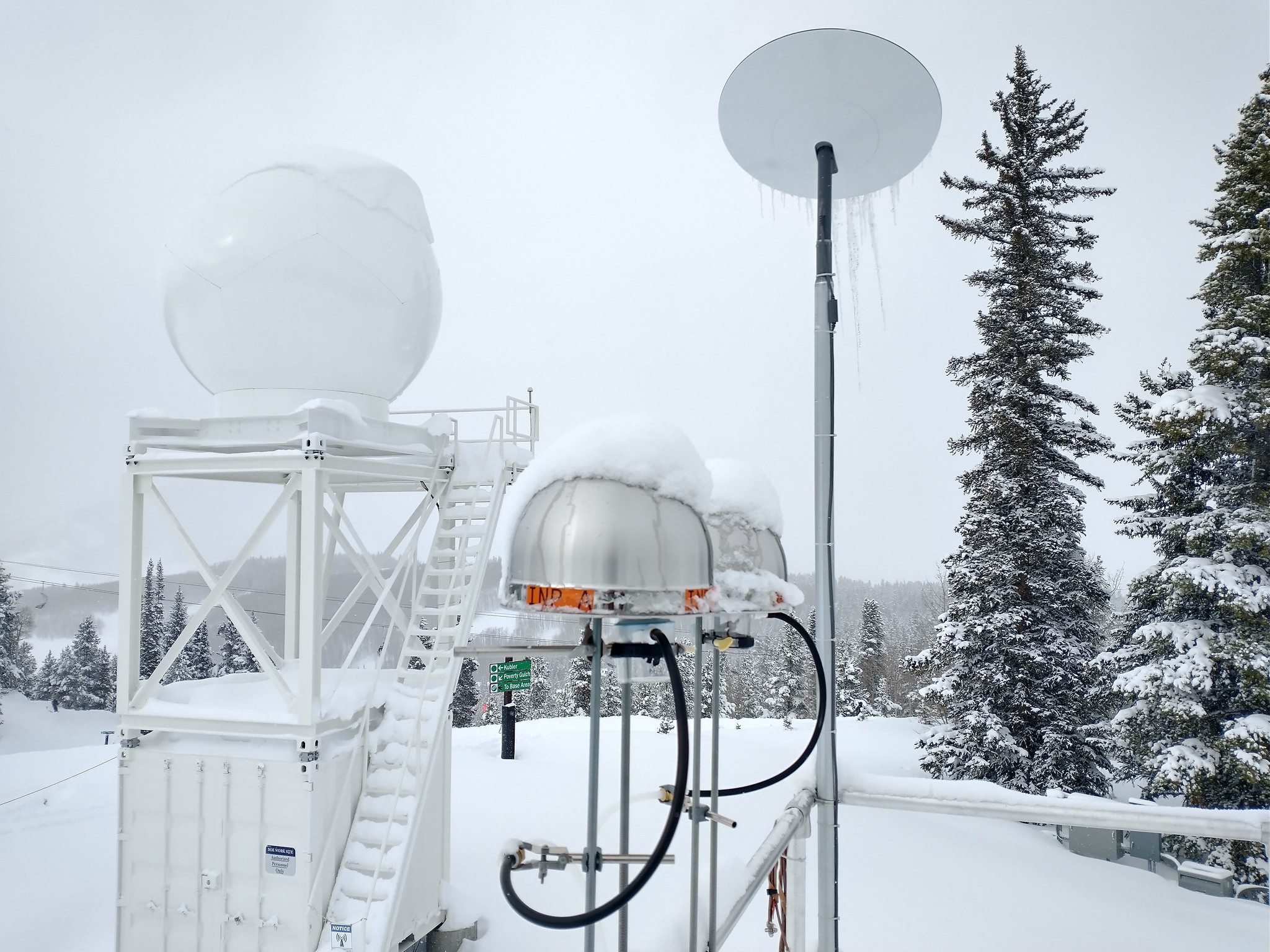 An ice nucleation spectrometer (INS) and an X-band precipitation radar (XSAPR) are pictured on Crested Butte Mountain in Colorado as part of the Surface Atmosphere Integrated Field Laboratory (SAIL) campaign.