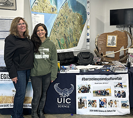 Valerie Sparks (left) poses with Telayna Wong, a UIC Science project manager, in front of a table at the Barrow Arctic Research Center (BARC) Science and Culture Fair in August 2024. Photo is courtesy of Valerie Sparks, Sandia National Laboratories.